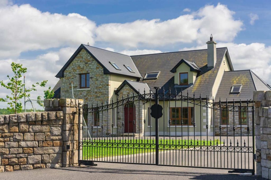 A,Beautiful,Residential,House,And,Artistic,Wrought,Iron,Gate.